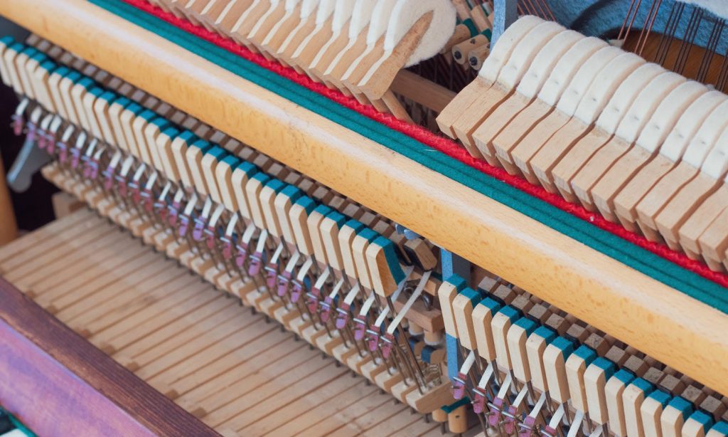 piano action with hammers and wooden keys